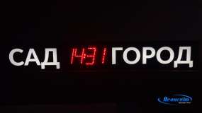 Световой лайтбокс в темноте, уличные LED-часы показывают текущее время