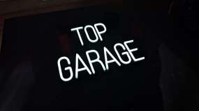Готовая неоновая вывеска Top Garage во включенном состоянии, вид слева под углом