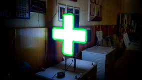 Двосторонній світловий аптечний хрест 600 мм у ввімкненому стані, вид з іншої сторони