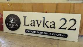 Рекламна вивіска LAVKA 22 у зборі в майстерні у вимкненому стані з круглим і прямокутним лайтбоксами та плоскими літерами з чорного композиту